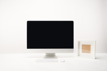workplace with photo frame and desktop computer with copy space isolated on white