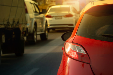 Red car with other cars break on the road by traffic jam on morning in the city.