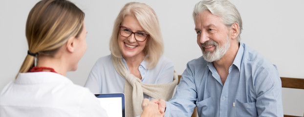 Horizontal photo grey-haired couple aged family meet with real estate agent in office greeting make...