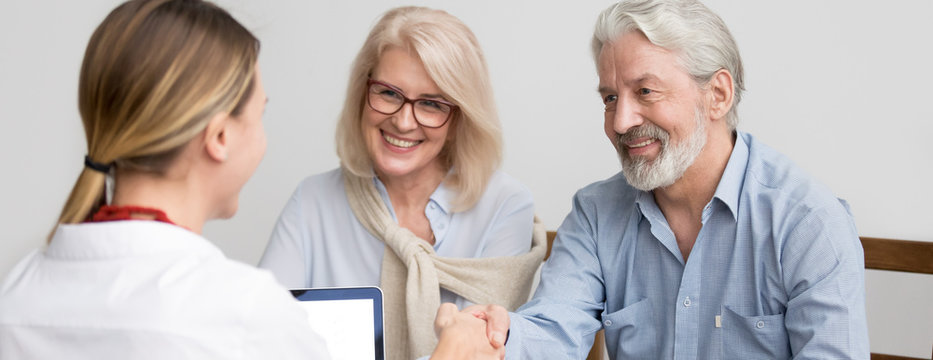 Horizontal photo grey-haired couple aged family meet with real estate agent in office greeting make deal shake hands buy home, leasing bank insurance services concept, banner for website header design
