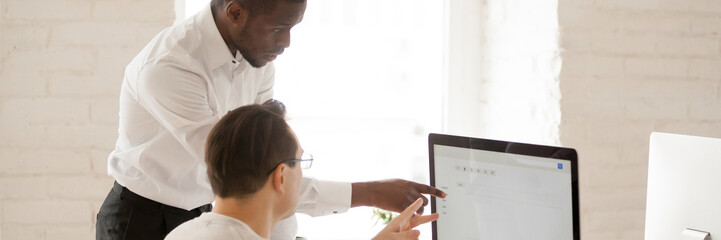Horizontal image african team leader help colleague with computer task showing new corporate app,...
