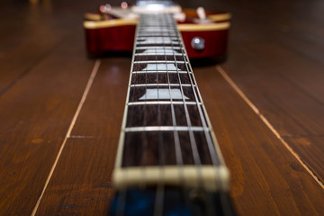 Electric guitar neck in focus on wood floor , image for background.