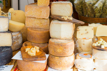Various Cheeses For Sale At Market Stall.