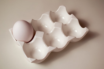 White ceramic egg holder with egg.