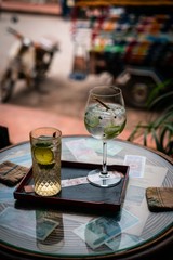 Alcoholic drink with lemon and ice on a old glas table