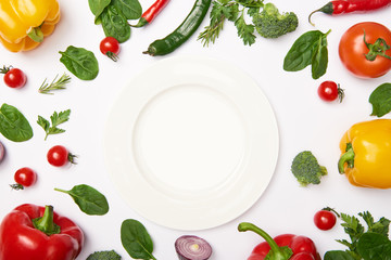 Flat lay with plate and natural vegetables on white background