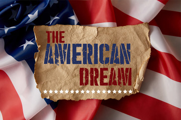 Fototapeta na wymiar vintage crumpled paper with the american dream lettering on american flag
