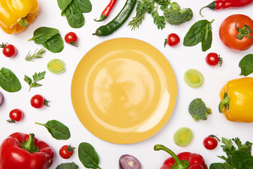 Flat lay with yellow plate and vegetables on white background