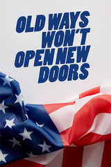top view of united states of america flag and old ways wont open new doors quote on white surface