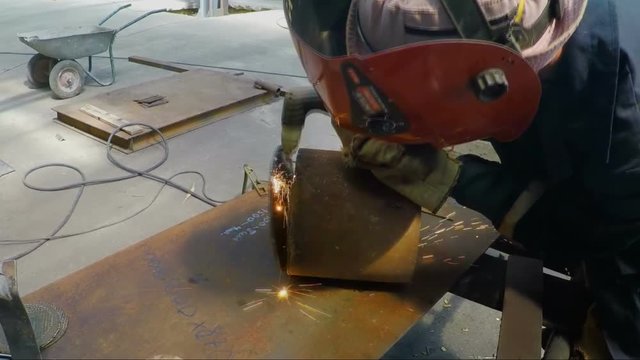 Welder cutting steel billet