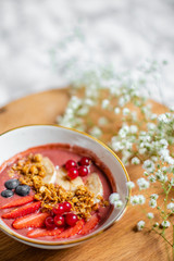 oatmeal with berries on the table with flowers
