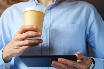 Obraz na płótnie Canvas Businessman using digital tablet and drinking coffee. Smartphone Paper Cup Shirt Beard. Office Coffee Break Concept