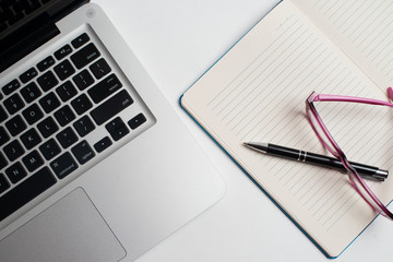 Notebook with black pen, Colorful notepads on the desk, Glasses on the desk with pen and cup of coffee, Computer keyboard with colorful note stick