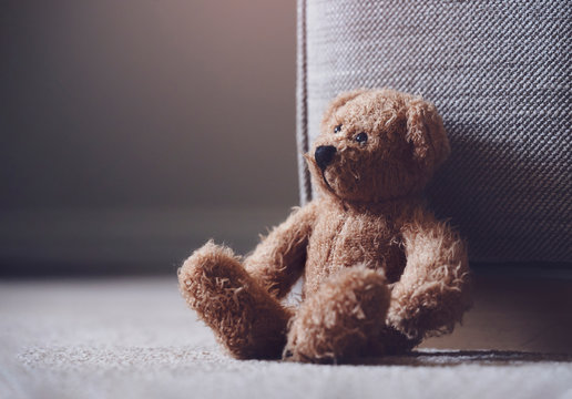 Naklejki Teddy bear is laying down on carpet in retro filter, Lonely teddy bear laying down alone in living room at night ,lonely concept, international missing children's day.