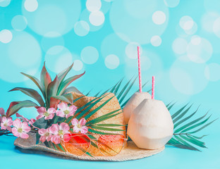 Female beach accessories with fresh coconut, drinking straws and tropical leaves and flowers ,...