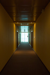 Empty hotel interior, light at the end corridor. The end concept