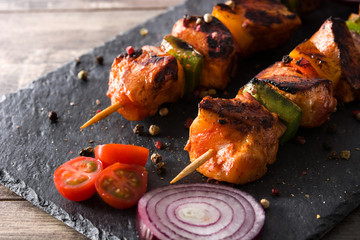 Chicken shish kebab with vegetables on wooden table

