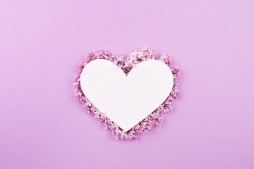 white heart decorated with lilac flowers on purple background. Card for Valentine's day, mother's day, women's day with love