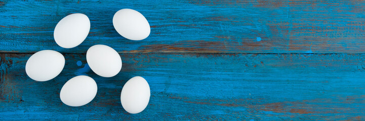 Frame of Easter eggs with a place for the inscription on a blue wooden background. Copy space .
