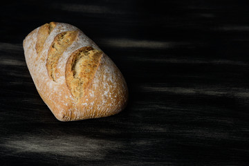 Loaf of bread on dark wooden background