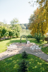Fototapeta premium Wedding ceremony with beautiful floral wedding arch of white roses in the garden. Arch. Floristics.