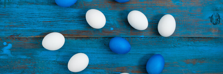 Creative egg layout painted blue and white on a blue wooden background