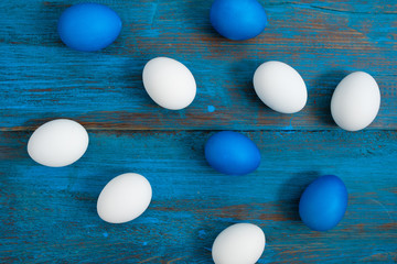Creative egg layout painted blue and white on a blue wooden background