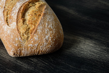 Loaf of bread on dark wooden background