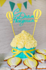 Festive decor candy bar birthday party with cookies and cupcakes. stylized holiday. The inscription on the cake rerevod from Russian: Happy birthday