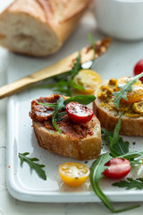 bruschettas with chopped tomato and basil on white ceramic plate. Top view.