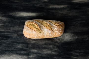 Loaf of bread on dark wooden background