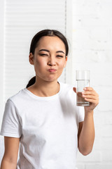 young asian woman in white t-shirt rinsing mouth with water