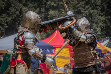 Medieval knights fighting with armor, swords and shields in festival