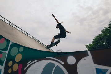Skateboarder jumping on ramp at city park