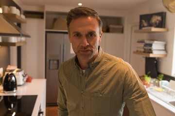Obraz premium Man standing in kitchen at home