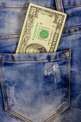 Twenty dollars bill in the pocket of blue jeans