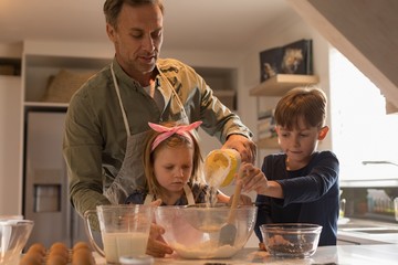 Father with his children preparing food in kitchen