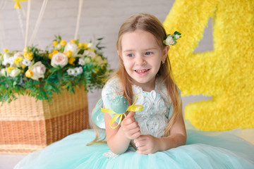 Obraz na płótnie Canvas cute happy birthday girl in a studio with a festive decor celebrates a birthday, sweets decor candy bar in yellow green color