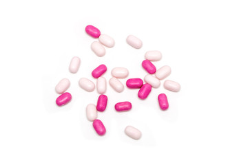 Obraz na płótnie Canvas pink and white medicine pills scattered on the table