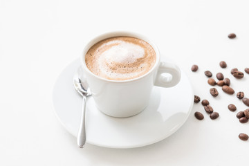 Morning coffee lifestyle. Hot invigorating drink. Latte cup with milk foam and beans on white background.