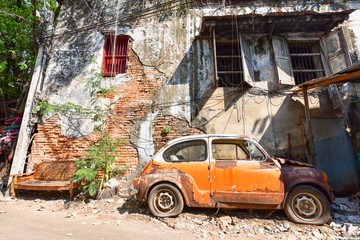Abandoned Vintage Car with Brick Walls in the Background in Talad Noi Neighbourhood