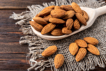 Almond on dark wooden background.