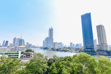 Fototapeta premium View of Chao Phraya River with Modern Buildings Along River Banks in Bangkok