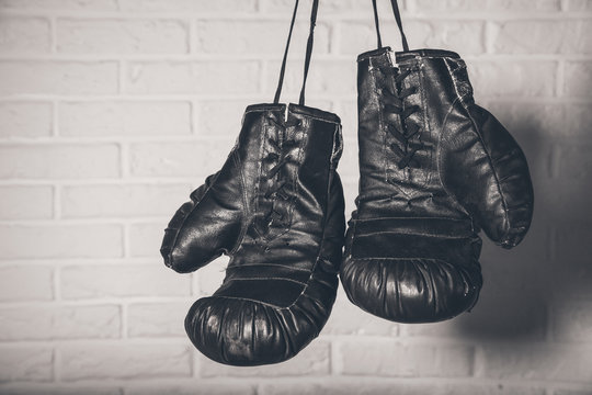 Hanging Boxing gloves on brick wall background