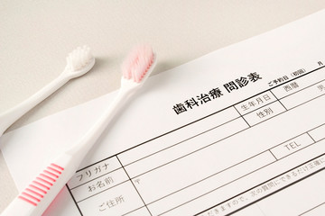 歯の治療の問診票と歯ブラシ