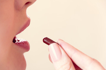 girl takes a pill with her mouth