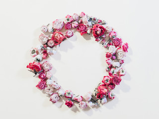 Festive flower composition. Congratulation concept. Dried rose wreath on ivory background.