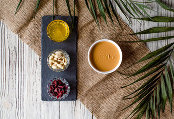 Flat lay with peanut butter, honey and dried cranberries.