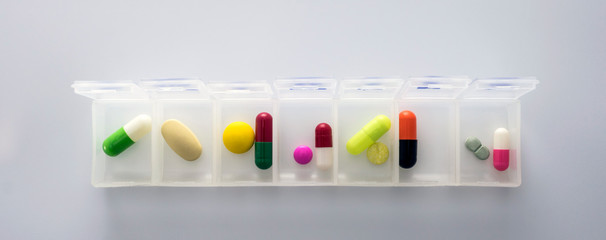 weekly pillbox with medication, conceptual image, horizontal composition