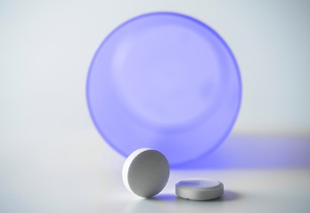 Tablets with isolated bottle on white background, conceptual image